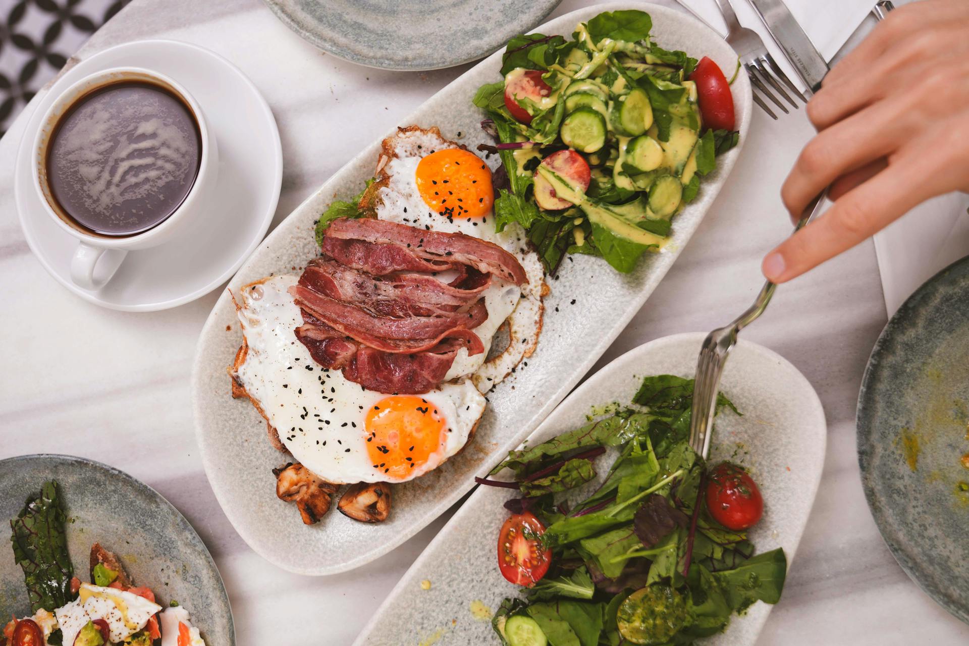 Gedeckte rTisch mit Speck, Spiegelei und Salat