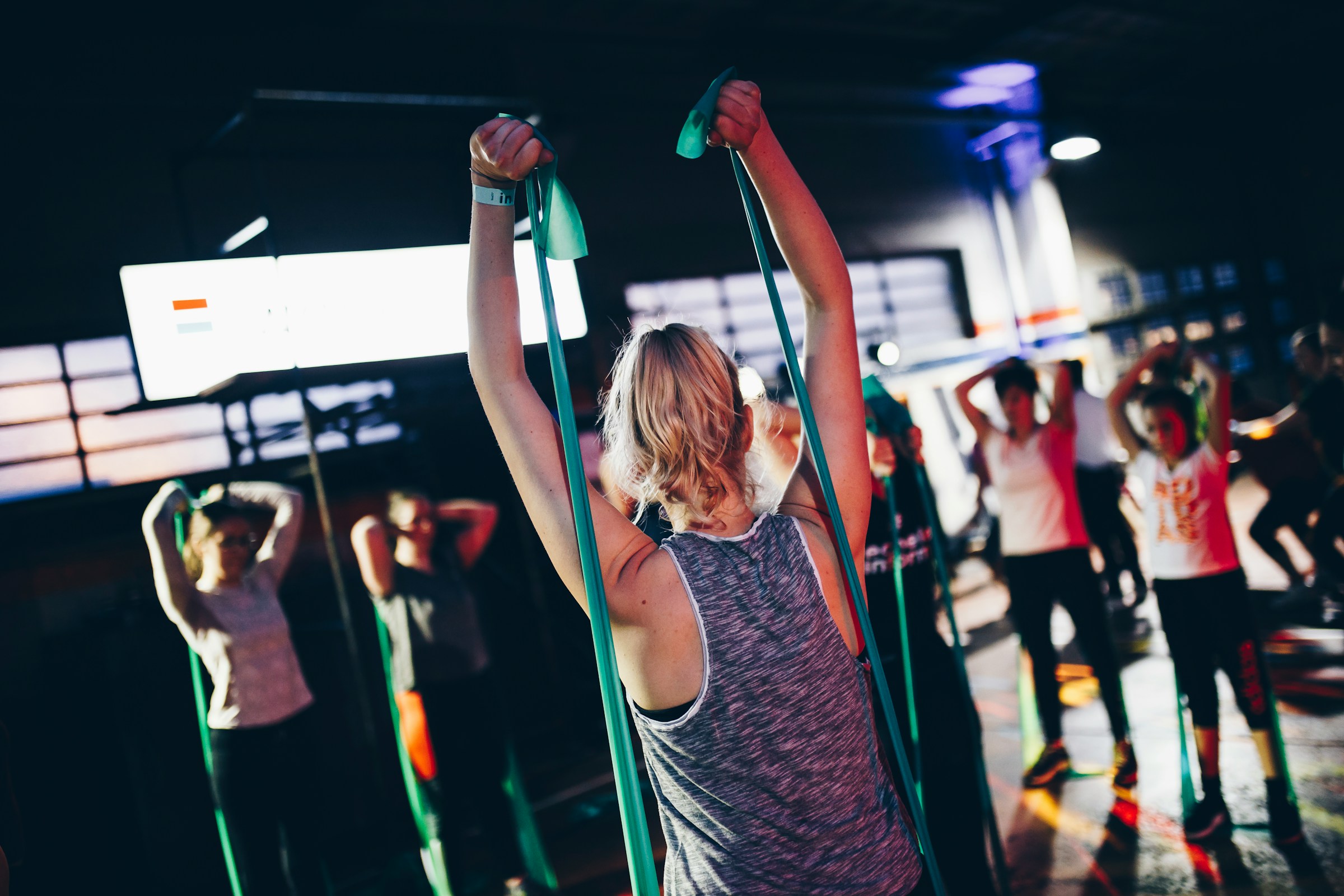 Eine Gruppe sportlicher Frauen trainiert mit Widerstandsbändern imt Fitnessstudio